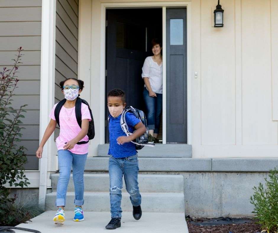 mother at front door watching son and daughter walk to school
