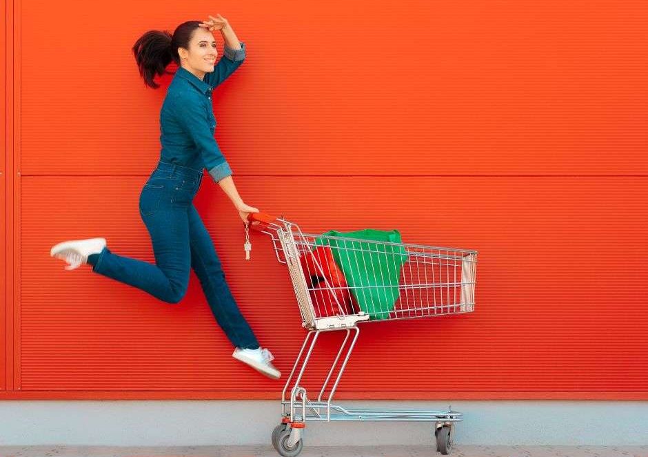 woman jumping pushing supermarket trolley